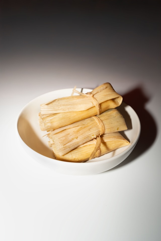 A plate of tamales ontop of a white table.